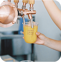 写真：サーバーからオレンジジュースを注いている