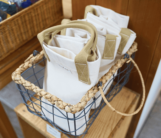 写真:カゴに帆布でできたトートバックが沢山入っています